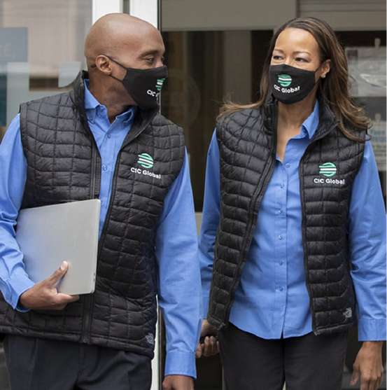 Two staff in black quilted bodywarmers over blue shirts