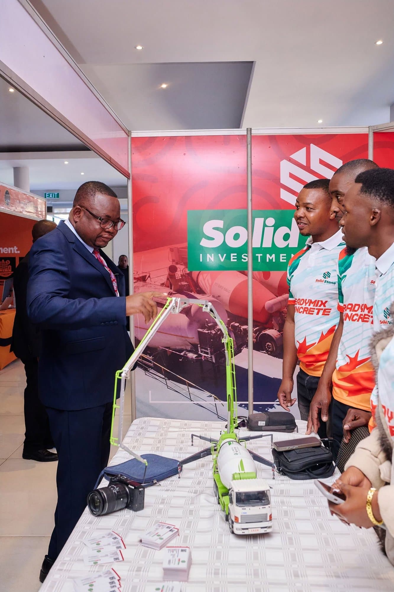 Exhibition staff in matching branded sublimated golf shirts at a trade-show stand