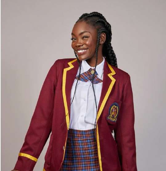 Student in a maroon blazer with gold piping and a school badge